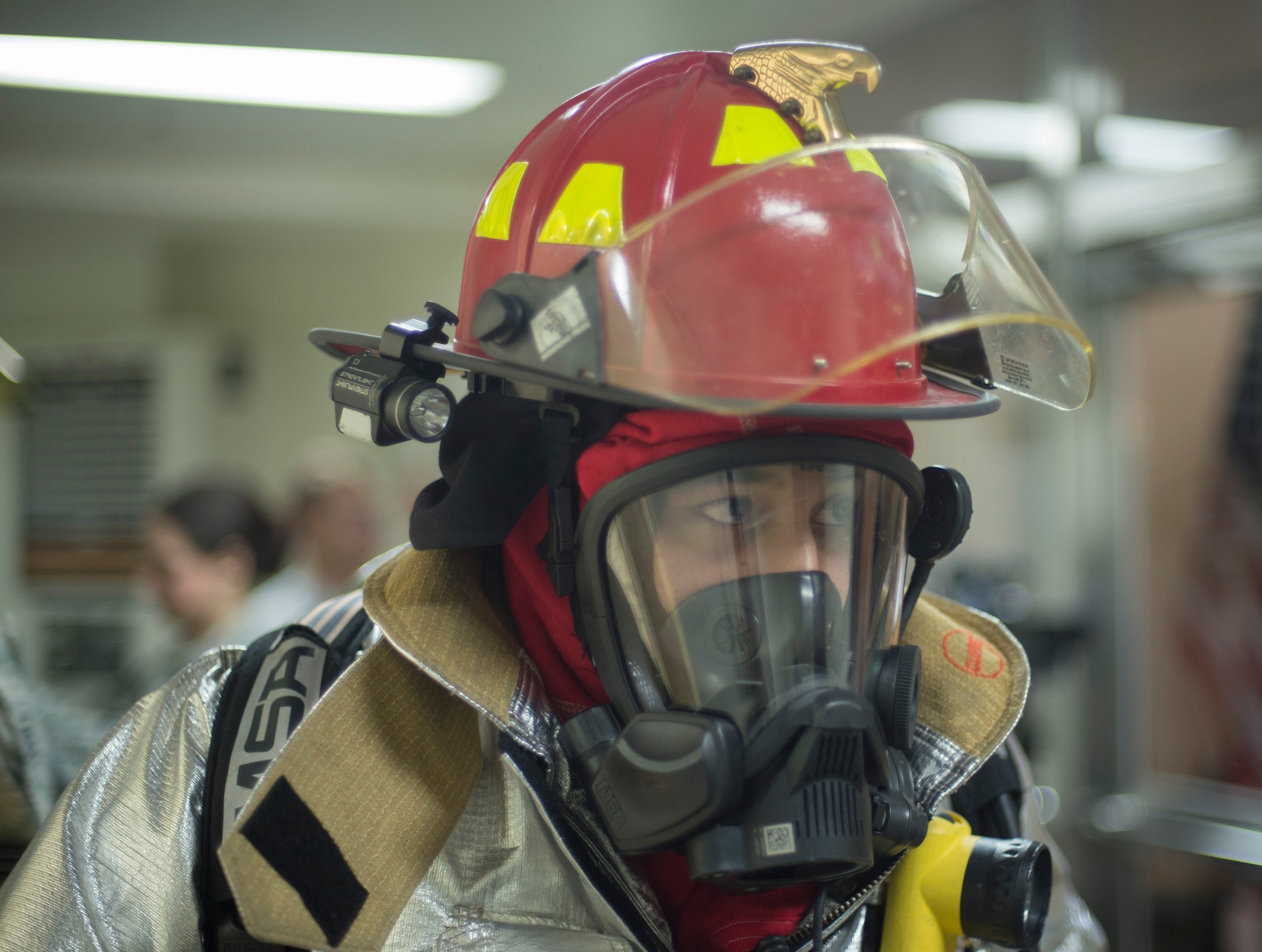 Tech. Sgt. Stephen Sanabria, 374 Civil Engineer Squadron firefighter, dons his gear before ascending and descending nine flights of stairs during the Sept. 11 Tower Run at Yokota Air Base, Japan, Sept. 11, 2014. Although Sanabria participated in full gear, competitors were only required to wear a 30-pound oxygen tank on their back. (U.S. Air Force photo by Senior Airman Michael Washburn/released)