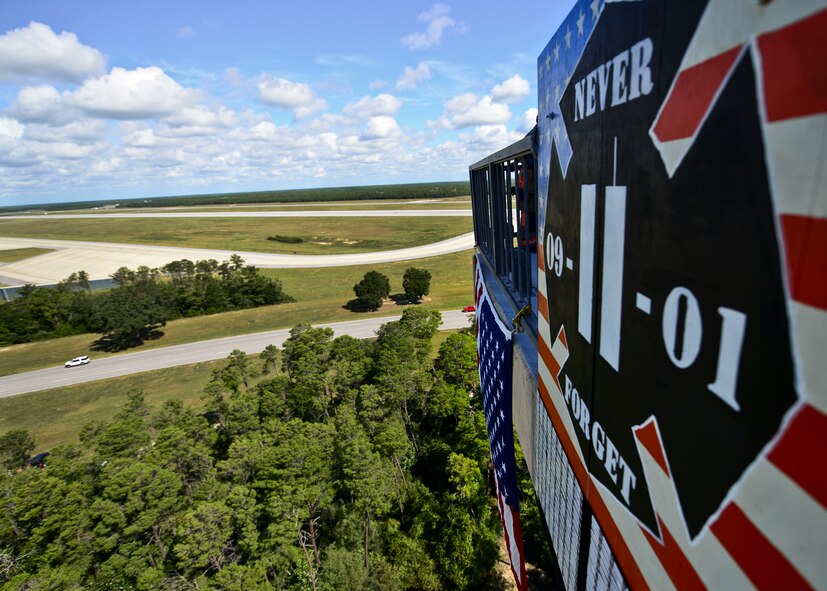 An American Flag and the names of the 343 firefighters killed Sept. 11 2001 hang over the side of the Eglin Air Force Base air traffic control tower Sept. 11. Fire department Airmen and civilians ascended the 11-story air traffic control tower multiple times to deliver identification tags of the fallen to the top. When each name was delivered, it was read aloud. (U.S. Air Force photo/Samuel King Jr.)