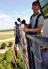 Eglin Air Force Base firefighters attach the 9/11 memorial display to the balcony of the air traffic control tower Sept. 11. Firefighters carried identification tags of each of the 343 firefighters killed on 9/11 to the top of the control tower to be placed on the display.  Once at the top, the name was read aloud.  (U.S. Air Force photo/Tech. Sgt. Cheryl L. Foster)