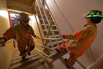 Eglin Air Force Base firefighters climb the stairs of the air traffic control tower to deliver identification tags of the 343 firefighters killed Sept. 11, 2001 to the memorial display at the top. Once at the top, the name was read aloud.  The event ended with participants hanging the display over the balcony of the tower with an American Flag. (U.S. Air Force photo/Tech. Sgt. Cheryl L. Foster)
