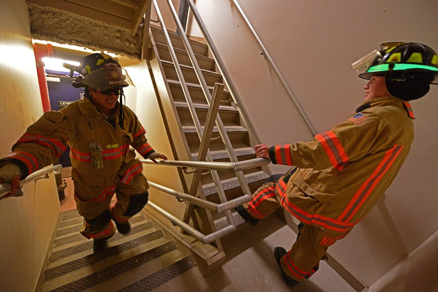 Eglin Air Force Base firefighters climb the stairs of the air traffic control tower to deliver identification tags of the 343 firefighters killed Sept. 11, 2001 to the memorial display at the top. Once at the top, the name was read aloud.  The event ended with participants hanging the display over the balcony of the tower with an American Flag. (U.S. Air Force photo/Tech. Sgt. Cheryl L. Foster)
