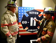 An Eglin Air Force Base firefighter presents a tag with a name of one of the 343 firefighters killed Sept. 11, 2001 to Fire Chief Mark Giuliano after ascending to the top 11-story air traffic control tower Sept. 11. When each name was delivered to the top of the tower it was read aloud. The event ended on top of the tower with participants hanging the tag display over the balcony with an American Flag. (U.S. Air Force photo/Tech. Sgt. Cheryl L. Foster)
