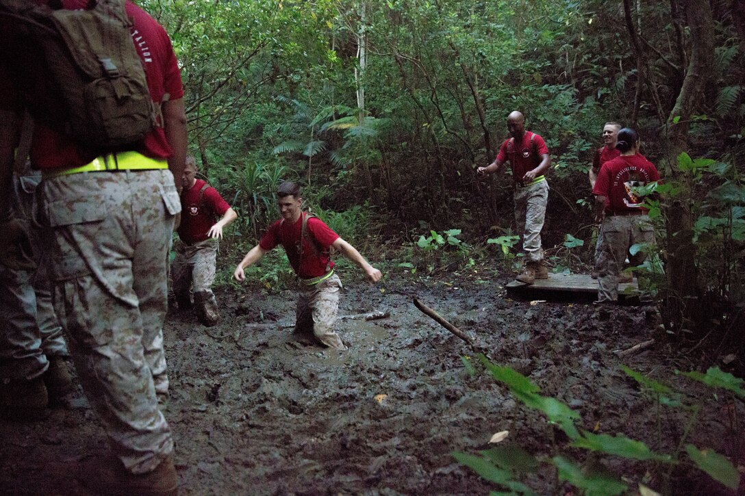Marines with 3rd Intelligence Battalion, III Marine Expeditionary Force Headquarters Group, wade through mud pits Sept. 11 during an endurance course at Camp Hansen as part of a 9/11 commemorative training day. “If our Marines got only one thing out of today's event, it's that 9/11 fundamentally changed our world and that we must be prepared and ready for the hard challenges that still lay ahead,” said Lt. Col. Mike D. Reilly, a Houston, Texas, native and the commanding officer of 3rd Intel Bn., III MHG, III MEF.