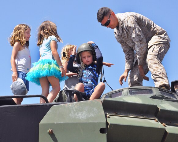 Following a street ride in the Assault Amphibious Vehicle, a Marine assigned to Marine Corps Systems Command's Amphibious Vehicle Test Branch shows girls around the vehicle. Through a community partnership with the YMCA, AVTB sponsored the YMCA Adventure Princess Program Sept. 6 at Camp Pendleton, California. During the event, AVTB provided demonstrations, displays and tours for 37 fathers and 48 daughters from the local community.