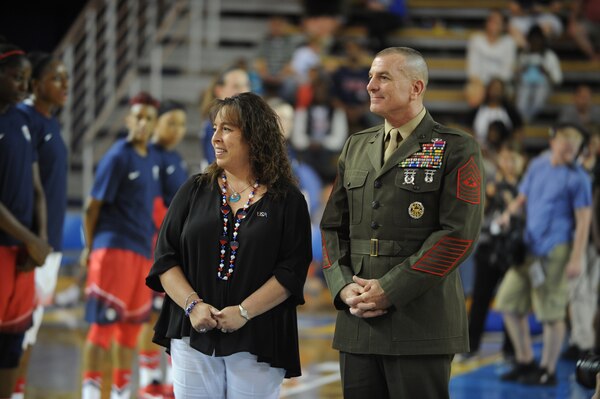 Senior Enlisted Advisor to the Chairman of the Joint Chiefs of Staff Marine Corps Sgt. Maj. Bryan Battaglia and his wife, Lisa, look on as service members from the Army, Marines Corps, Navy, Air Force and Coast Guard prepare to present unique dog tags to the USA Women's National Basketball Team during halftime of the Red versus White game at the Bob Carpenter Center at the University of Delaware Sept. 11. The USA Women's National Basketball Team scrimmaged against one another for more than 2,000 fans. This engagement is part of Army Gen. Martin Dempsey's, the Chairman of the Joint Chiefs of Staff, Commitment to Service Sports Outreach Initiative.
