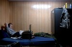 Staff Sgt. Jason Whitekettle of the Maryland Army National Guard's 58th Infantry Brigade Combat Team relaxes on his bunk at Camp Victory, Iraq, by playing a video game on his laptop computer during a deployment in 2008. Many servicemembers in Iraq pass downtime by playing video games or watching movies on their computers and often trade games and movies among each other.