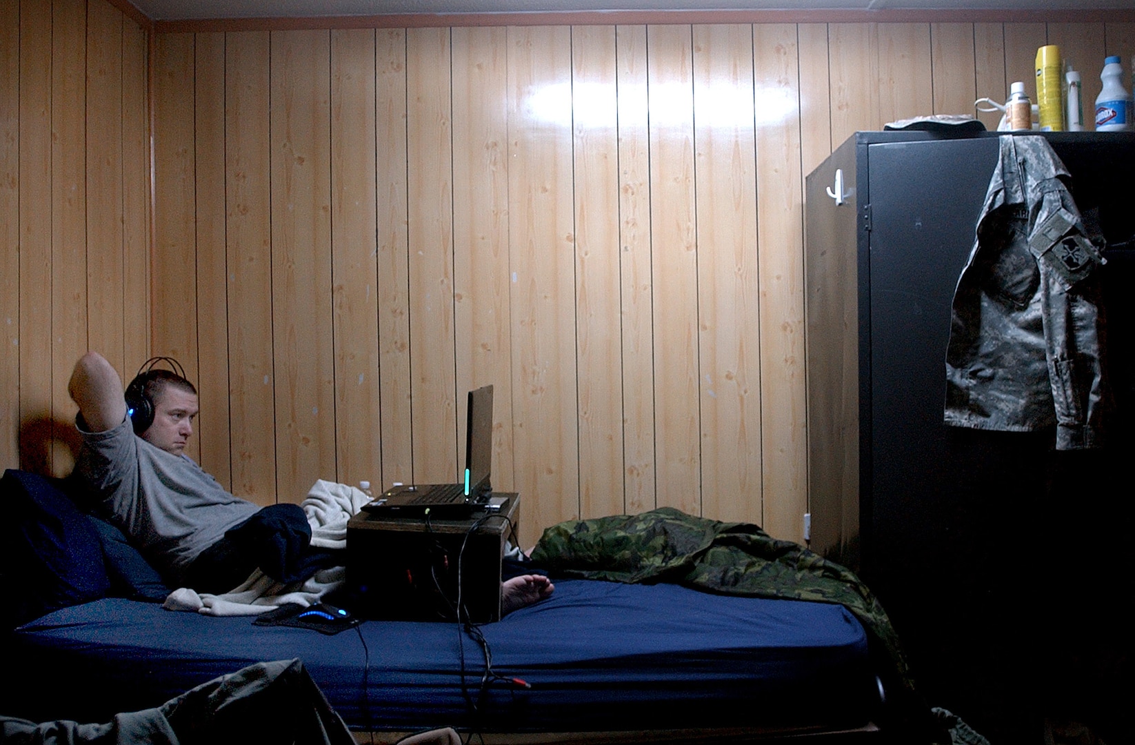 Staff Sgt. Jason Whitekettle of the Maryland Army National Guard's 58th Infantry Brigade Combat Team relaxes on his bunk at Camp Victory, Iraq, by playing a video game on his laptop computer during a deployment in 2008. Many servicemembers in Iraq pass downtime by playing video games or watching movies on their computers and often trade games and movies among each other.