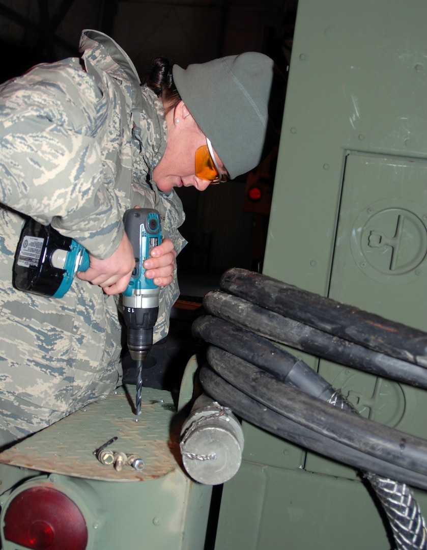 Airman 1st Class Devon Carroll, a member of the 260th Air Traffic Control Squadron-New Hampshire Air National Guard, begins installation of external fuel tank mounts on a MEP805 Generator. The generator is being prepared for deployment to Haiti along with the units mobile control tower and about 12 personnel in support of relief efforts after the recent earthquake.