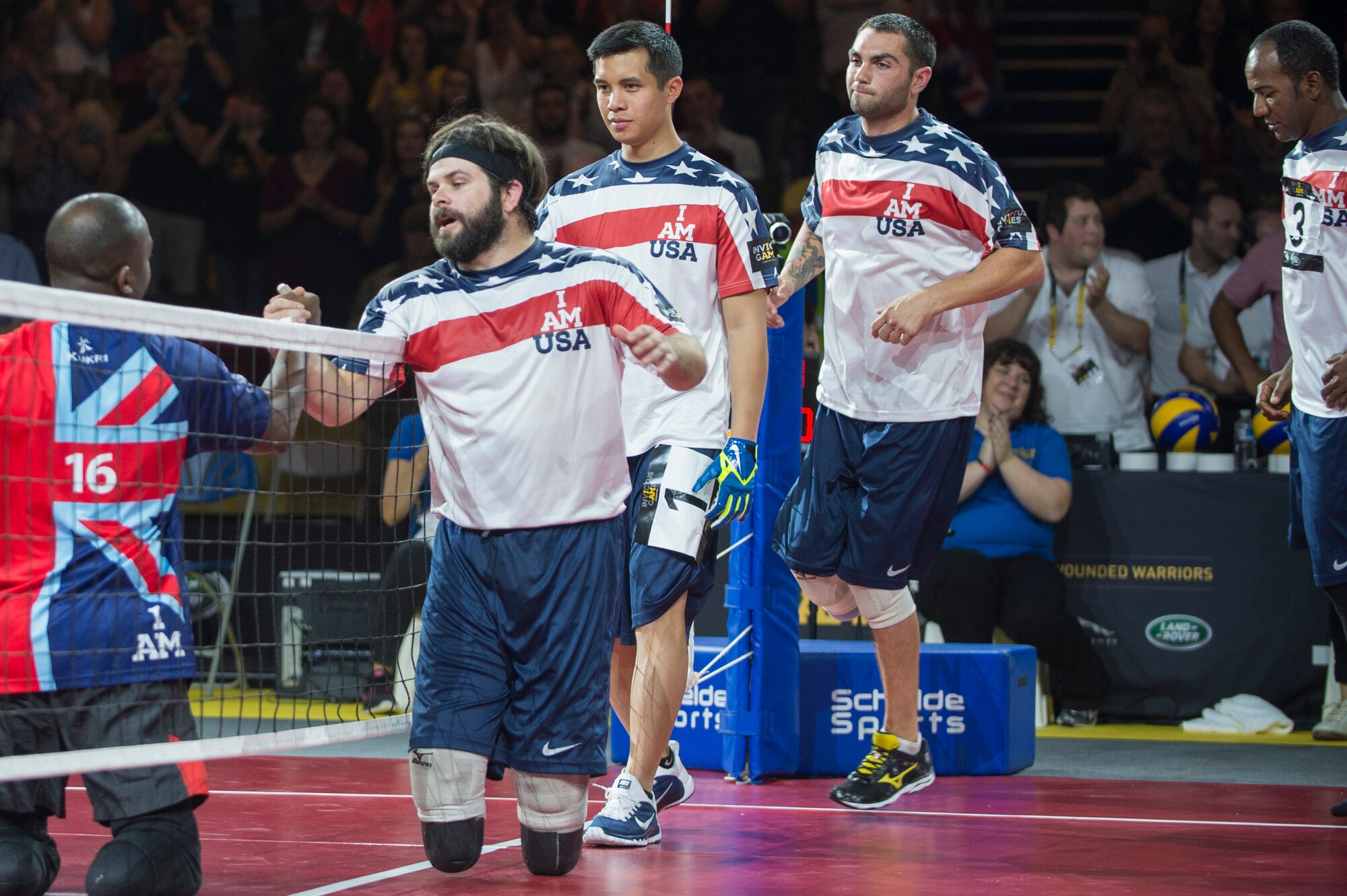 Navy Explosive Ordnance Disposal Technician 1st Class John Kremer and his U.S. teammates walk along the net to congratulate Great Britain, winners of the sitting volleyball event, at the inaugural Invictus Games Sept. 14, 2014, in London. Great Britain defeated the U.S. in a best-out-of-five match. The Invictus Games featured athletes competing in various Paralympic-style events, including swimming, track and field, seated volleyball, wheelchair basketball, and wheelchair rugby, among others. (U.S. Navy photo/Mass Communication Specialist 1st Class (SW) Mark Logico)
