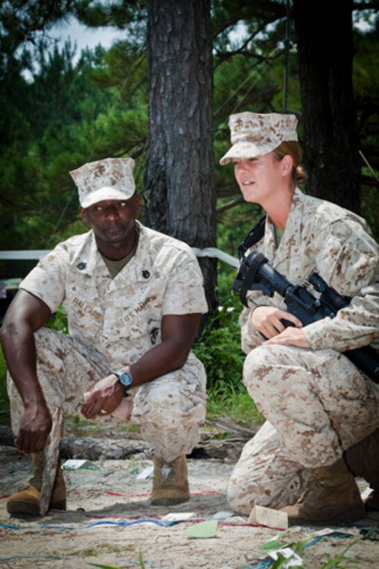 Staff Sergeant Christopher O. Ballard (left), Instructor, Logistics Officers Course (LOC), class 4-14, Logistics Operations School, Marine Corps Combat Service Support Schools, gives advice to 2nd Lieutenant Christina Rapp (right) a student, LOC, LOS, MCCSSS, class 2-14, during LOCs' field exercise that took place at landing zone Parrot aboard Camp Lejeune, N.C. Aug. 5, 2014. The training is conducted to better prepare entry level logistics officers for challenges they may be faced with in the future. (U.S. Marine Corps Combat Camera photo by Sgt. Bryce J. Burton/released) 