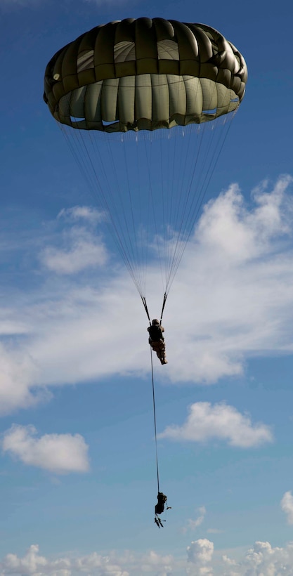 Cpl. David Meneses descends toward the ground following a 1,250-foot low-level static-line jump from an MV-22B Osprey tiltrotor aircraft Aug. 26 at Ie Shima Airfield, Okinawa, Japan. The jump simulated jumping into a hostile location with a full load of equipment. Meneses is from Orlando, Florida and is an airborne and air delivery specialist with Combat Logistics Regiment 3, 3rd Marine Logistics Group, III Marine Expeditionary Force. (U.S. Marine Corps photo by Lance Cpl. Matt Myers/Released)