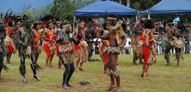 Staff Sgt. Melissa Pascua, Hawaii Air National Guard 154th Civil Engineer Squadron emergency management journeyman, center, performs a tribal dance with members of the Jiwaka Tribe during the closing ceremony for Pacific Unity 14-8. PACUNITY helps cultivate common bonds and fosters goodwill between the U.S. and regional nations through multi-lateral humanitarian assistance and civil military operations.  (U.S. Air Force photo by Tech. Sgt. Terri Paden/Released)                               