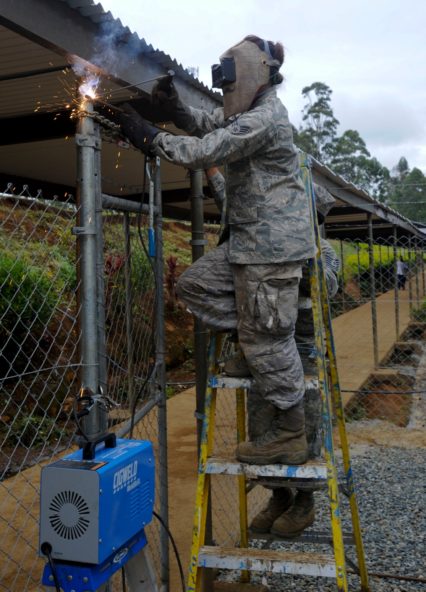 Senior Airman Jennie Abbott, Hawaii Air National Guard 154th Civil Engineer Squadron heavy equipment operator, welds rebar to a fence during Pacific Unity 14-8 in Mount Hagen, Papua New Guinea. As part of Pacific Unity the unit has been working on the construction of two new dormitories for female students, as well as performing other renovations and maintenance around the school. PACUNITY helps cultivate common bonds and fosters goodwill between the U.S. and regional nations through multi-lateral humanitarian assistance and civil military operations.  (U.S. Air Force photo by Tech. Sgt. Terri Paden/Released)                               