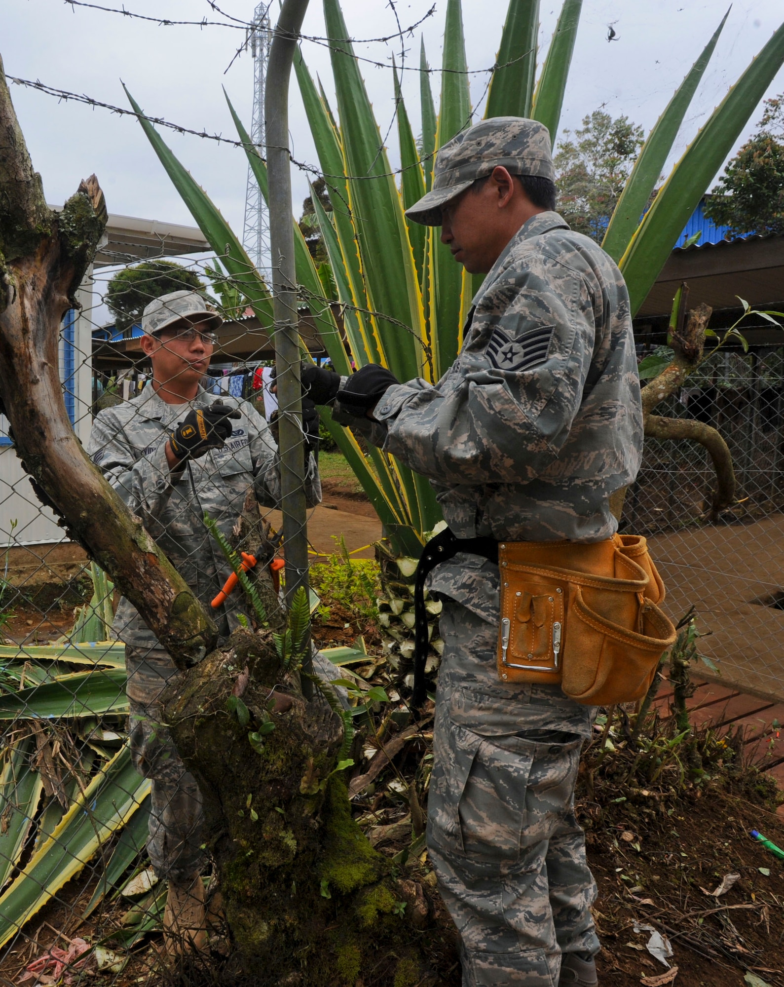 Senior Airman Paul Vidad, Hawaii Air National Guard 154th Civil Engineer Squadron engineering assistant, left, and Staff Sgt. Chris Aurio, Hawaii Air National Guard 154th Civil Engineer Squadron heating, ventilation and cooling journeyman, repair a fence at Togoba Secondary School in Mount Hagen, Papua New Guinea, as part of Pacific Unity 14-8. PACUNITY helps cultivate common bonds and fosters goodwill between the U.S. and regional nations through multi-lateral humanitarian assistance and civil military operations.  (U.S. Air Force photo by Tech. Sgt. Terri Paden/Released)                               