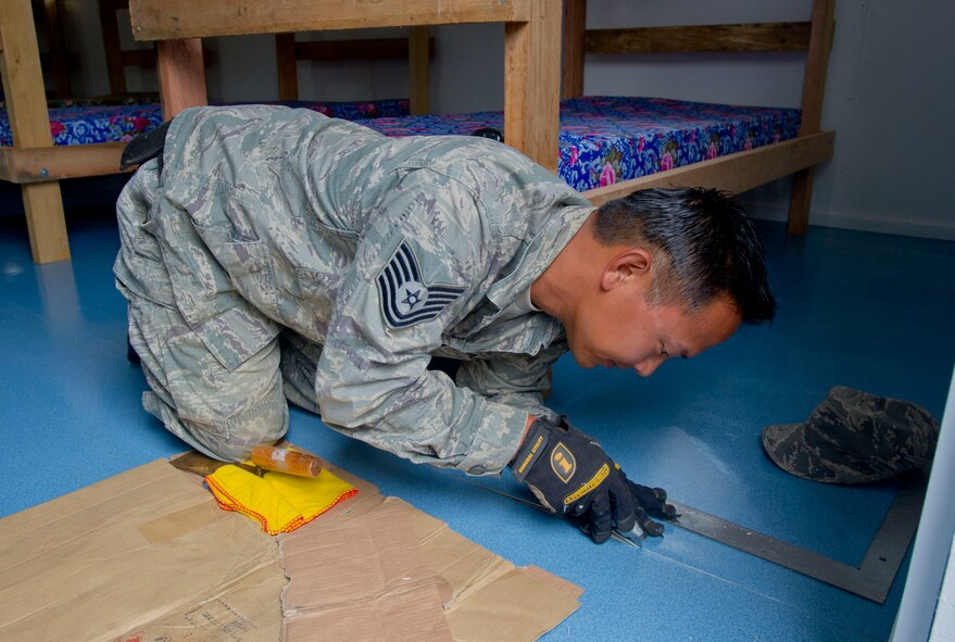 Tech. Sgt. Pat Takenishi, Hawaii Air National Guard 154th Civil Engineer Squadron heavy equipment operator works on the floor of a newly constructed dormitory at Togoba Secondary School in Mount Hagen Papua New Guinea, as part of Pacific Unity 14-8.  PACUNITY helps cultivate common bonds and fosters goodwill between the U.S. and regional nations through multi-lateral humanitarian assistance and civil military operations.  (U.S. Air Force photo by Tech. Sgt. Terri Paden/Released)                               