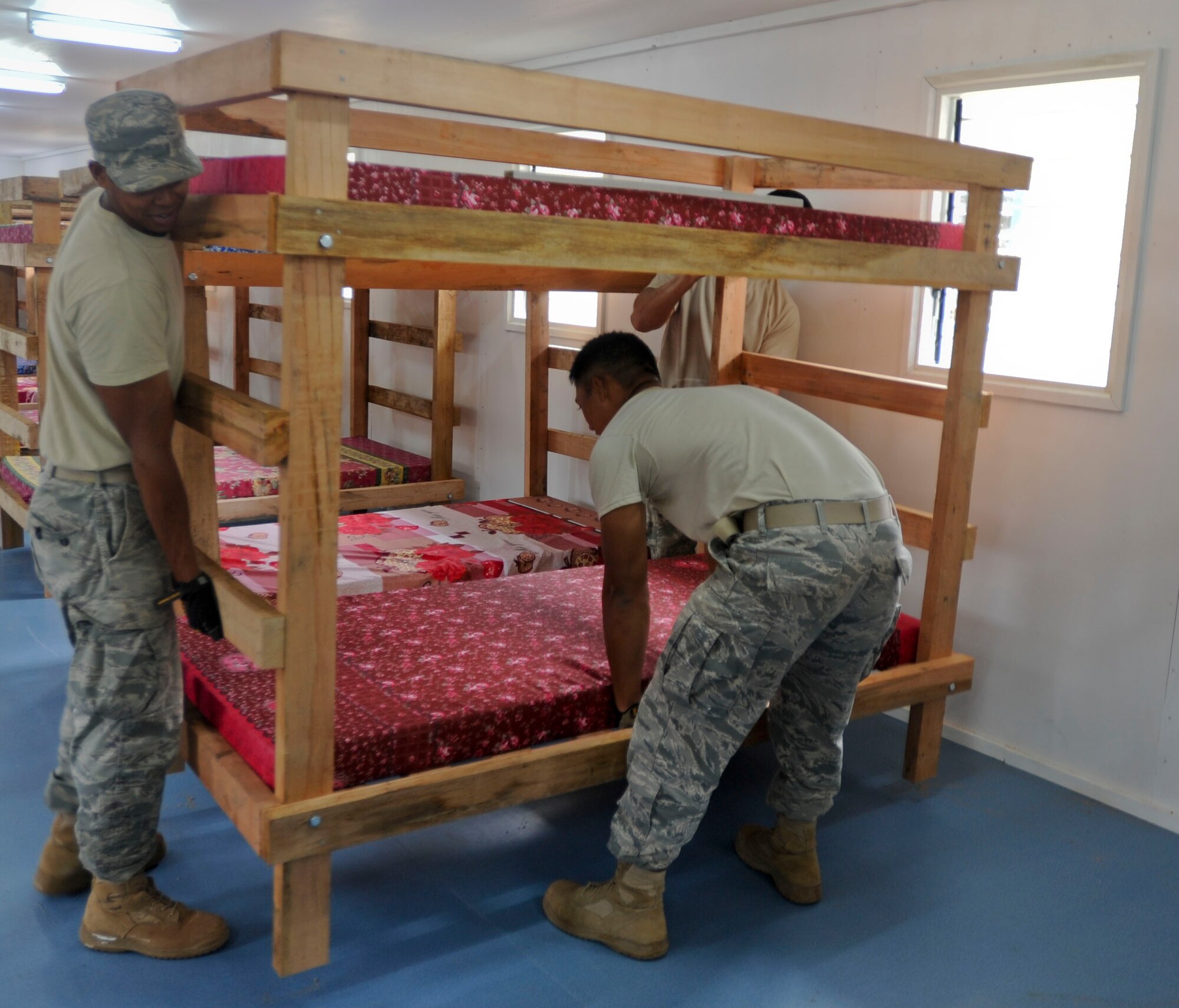 Members of the Hawaii Air National Guard 154th Civil Engineer Squadron move bunk beds into place inside a newly built dormitory at Togoba Secondary School as Pacific Unity 14-8 in Mount Hagen, Papua New Guinea, wraps up. PACUNITY helps cultivate common bonds and fosters goodwill between the U.S. and regional nations through multi-lateral humanitarian assistance and civil military operations.  (U.S. Air Force photo by Tech. Sgt. Terri Paden/Released)                               