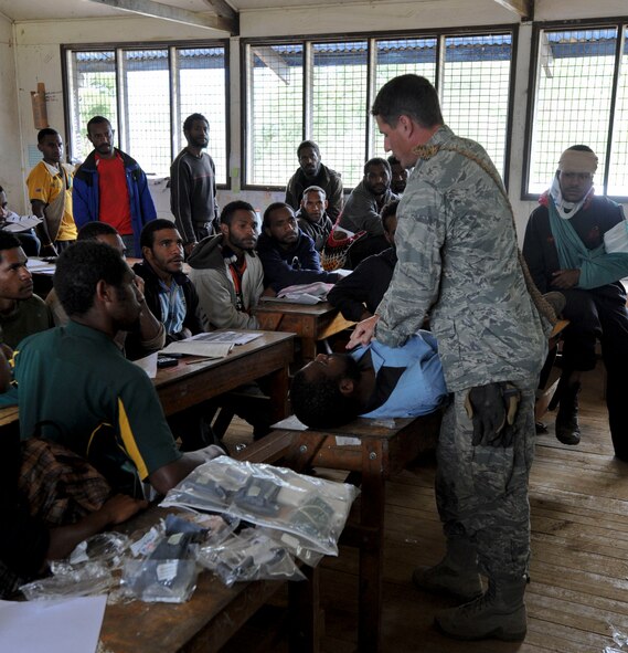 Maj. Nathaniel Duff, Hawaii Air National Guard 154th Medical Group and Pacific Unity 14-8 medical officer, demonstrates the proper way to wrap an injury during a basic first-aid clinic at Togoba Secondary School in Mount Hagen, Papua New Guinea. PACUNITY helps cultivate common bonds and fosters goodwill between the U.S. and regional nations through multi-lateral humanitarian assistance and civil military operations.  (U.S. Air Force photo by Tech. Sgt. Terri Paden/Released)