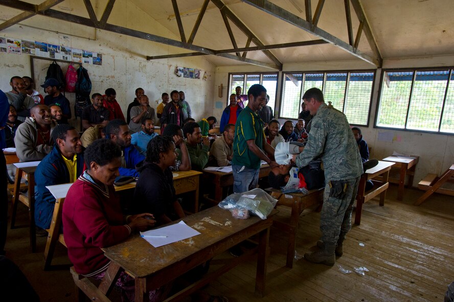 Maj. Nathaniel Duff, Hawaii Air National Guard 154th Medical Group and Pacific Unity 14-8 medical officer, shows a group of students how to perform cardiopulmonary resuscitation during a basic first-aid clinic at Togoba Secondary School in Mount Hagen, Papua New Guinea. PACUNITY helps cultivate common bonds and fosters goodwill between the U.S. and regional nations through multi-lateral humanitarian assistance and civil military operations.  (U.S. Air Force photo by Tech. Sgt. Terri Paden/Released)                               