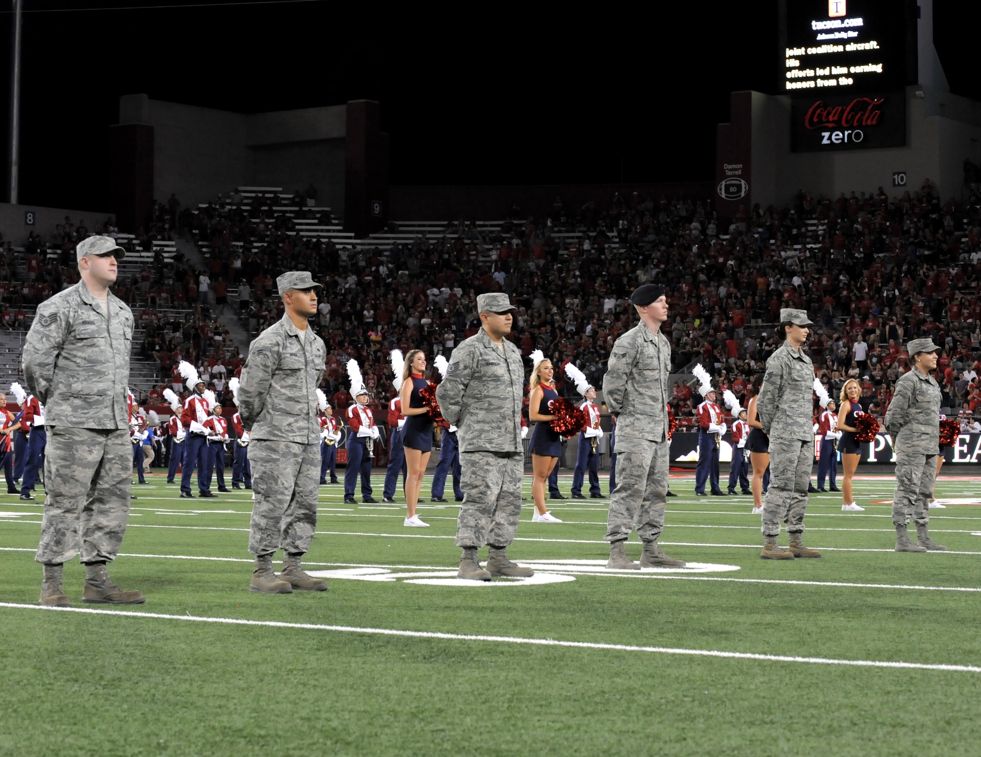 U.S. Air Force Airmen stationed at Davis-Monthan Air Force Base accept recognition for their service during a University of Arizona Wildcats football game at Arizona Stadium in Tucson, Ariz., Sept. 13, 2014. The Airmen were nominated by their supervisors for consistently exceeding standards. (U.S. Air Force photo by Airman 1st Class Chris Drzazgowski/Released)