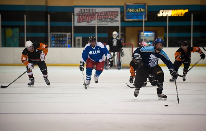 Staff Sgt. Derek Urban (dark blue jersey), a forward on the Nellis Air Force Base hockey team, leads a break during the Nellis team’s opening-season game against the Desert Foxes hockey team in Las Vegas Sept. 10, 2014. Urban scored goals in regulation and in the overtime shootout of Nellis’ 7-6 victory over the Desert Foxes. Urban is a contract administrator assigned to the 99th Contracting Squadron. (U.S. Air Force photo by Staff Sgt. Siuta B. Ika)