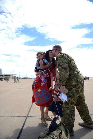 U.S. Air Force Lt. Col. Mitch Spillers, 40th Airlift Squadron director of operations, is embraced by his wife, Bridgett, and children as he returns from a deployment Sept. 15, 2014, at Dyess Air Force Base, Texas. While deployed as part of the 774th Expeditionary Airlift Squadron, the 40th AS executed the first humanitarian relief operation to aid more than 120,000 Badakhshan mudslide victims in northeast Afghanistan in May 2014. They flew the first aircraft into the area delivering critical supplies of food, water, tents, blankets and a forklift to support follow-on relief operations.  (U.S. Air Force photo by Airman 1st Class Kedesha Pennant/Released)