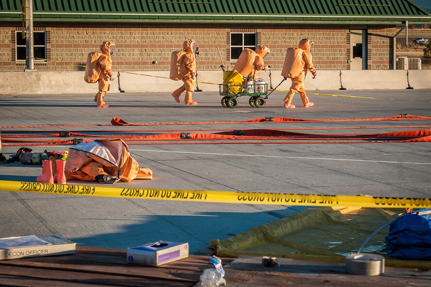 Craig Sayler, a 92nd Civil Engineer Squadron firefighter, walks with other regional firefighters in hazardous material suits as they enter the spill zone of a hazardous materials incident near the Washington-Idaho state line Sept. 14, 2014. A tanker truck leaking anhydrous trimethylamine, a flammable substance used in making solvents, animal feed supplements and products consumed by the paper, oil and gas industries, prompted emergency responders to shut down Interstate 90 garnering immense regional response including Fairchild Air Force Base firefighters. (U.S. Air Force photo/Staff Sgt. Benjamin W. Stratton)