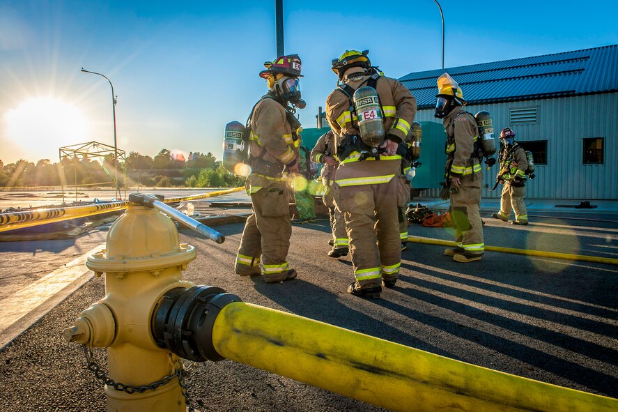Fairchild Air Force Base firefighters join other regional firefighters as they don their self-contained breathing apparatuses to perform decontamination support near the spill zone of a hazardous materials incident near the Washington-Idaho state line Sept. 14, 2014. Four Fairchild Air Force Base firefighters, one technician and a variety of support staff as well as the base’s mobile decontamination and rehabilitation unit joined two dozen other firefighters, trucks and equipment from Spokane regional fire districts in response to the incident. (U.S. Air Force photo/Staff Sgt. Benjamin W. Stratton)