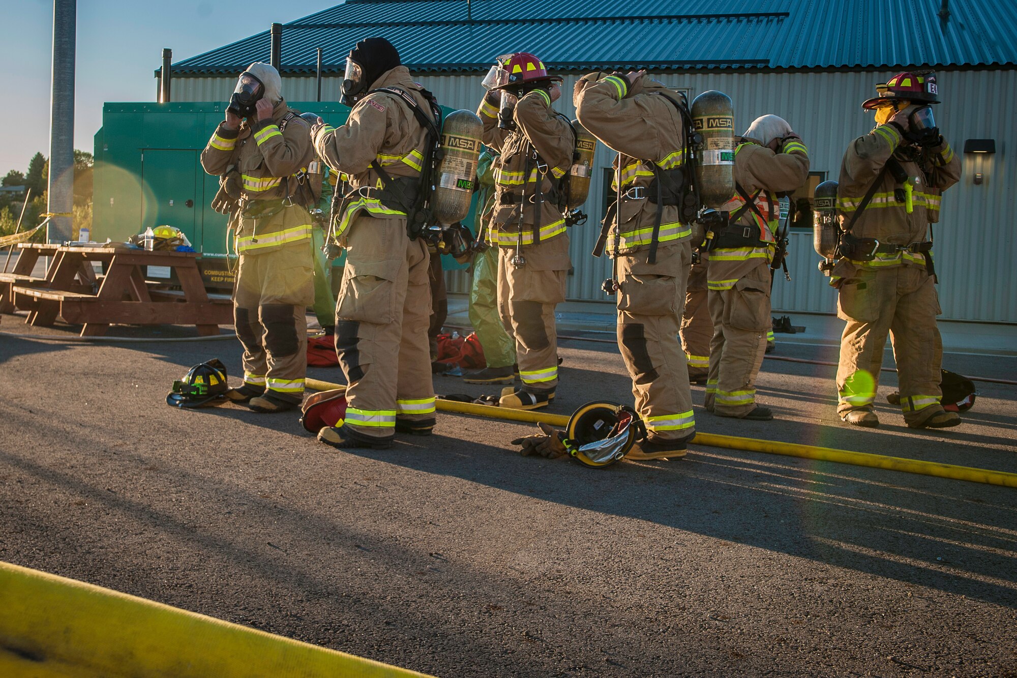 Fairchild Air Force Base firefighters join other regional firefighters as they don their self-contained breathing apparatuses to perform decontamination support near the spill zone of a hazardous materials incident near the Washington-Idaho state line Sept. 14, 2014. Four Fairchild Air Force Base firefighters, one technician and a variety of support staff as well as the base’s mobile decontamination and rehabilitation unit joined two dozen other firefighters, trucks and equipment from Spokane regional fire districts in response to the incident. (U.S. Air Force photo by Staff Sgt. Benjamin W. Stratton/Released)