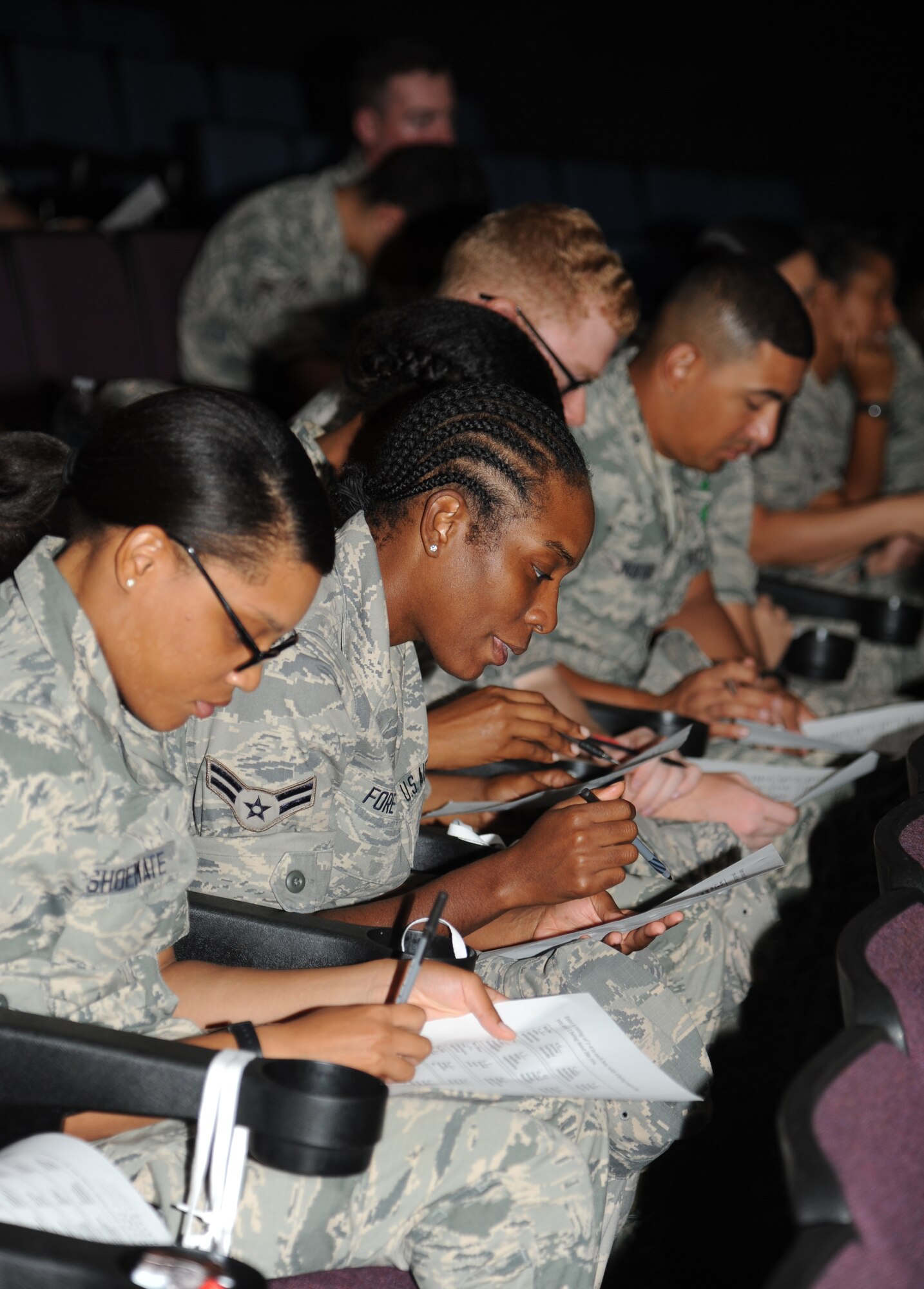 Airman 1st Class Portia Fore, 335th Training Squadron, center, completes a personality test which show leadership style during an Airmen Building Airmen program Sept. 12, 2014, at the Welch Theater, Keesler Air Force Base, Miss.  The goal of the symposium was to create a platform where outstanding Airmen can impart their wisdom to the next generation of Airmen.  The event included guest speakers and a social mixer. (U.S. Air Force photo by Kemberly Groue)