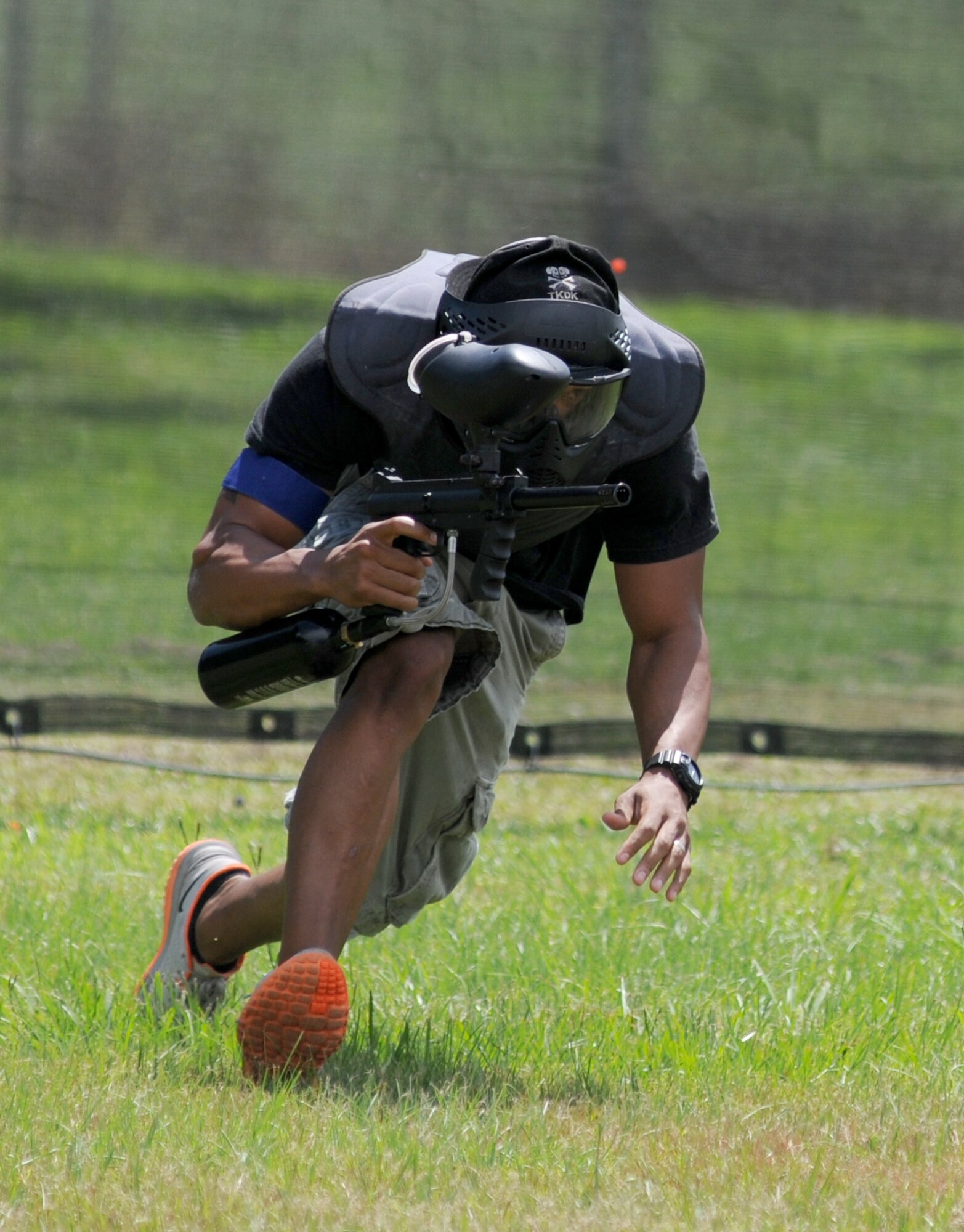 Staff Sgt. Errol Wallace, 81st Logistics Readiness Squadron, runs low to avoid getting hit by paintballs during the Fisher House Fundraiser paintball tournament Sept. 12, 2014, at the paintball complex, Keesler Air Force Base, Miss.  The event also included food, games and a dunking booth. (U.S. Air Force photo by Kemberly Groue)