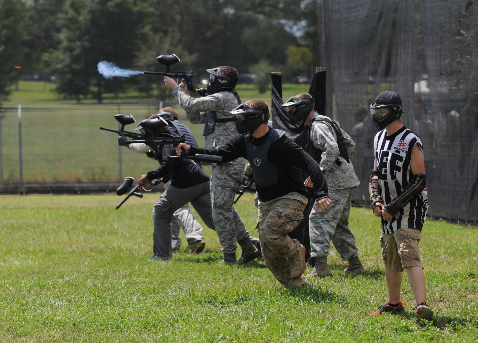 Members of the Fab Five Commanders team run for cover as they compete during the Fisher House Fundraiser paintball tournament Sept. 12, 2014, at the paintball complex, Keesler Air Force Base, Miss.  The event also included food, games and a dunking booth. (U.S. Air Force photo by Kemberly Groue)