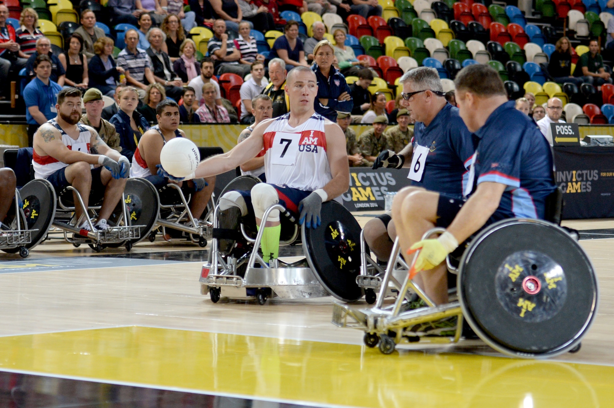 Army Sgt. Ryan McIntosh, representing the U.S., passes the ball around two defenders during a wheelchair rugby match against Australia Sept. 12, 2014, at the 2014 Invictus Games in London. The U.S. won the match 14-4. Invictus Games is an international competition that brings together wounded, injured and ill service members in the spirit of friendly athletic competition. American Soldiers, Sailors, Airmen and Marines are representing the U.S. in the competition which is taking place Sept. 10-14. (U.S. Navy photo/Mass Communication Specialist 2nd Class Joshua D. Sheppard)
