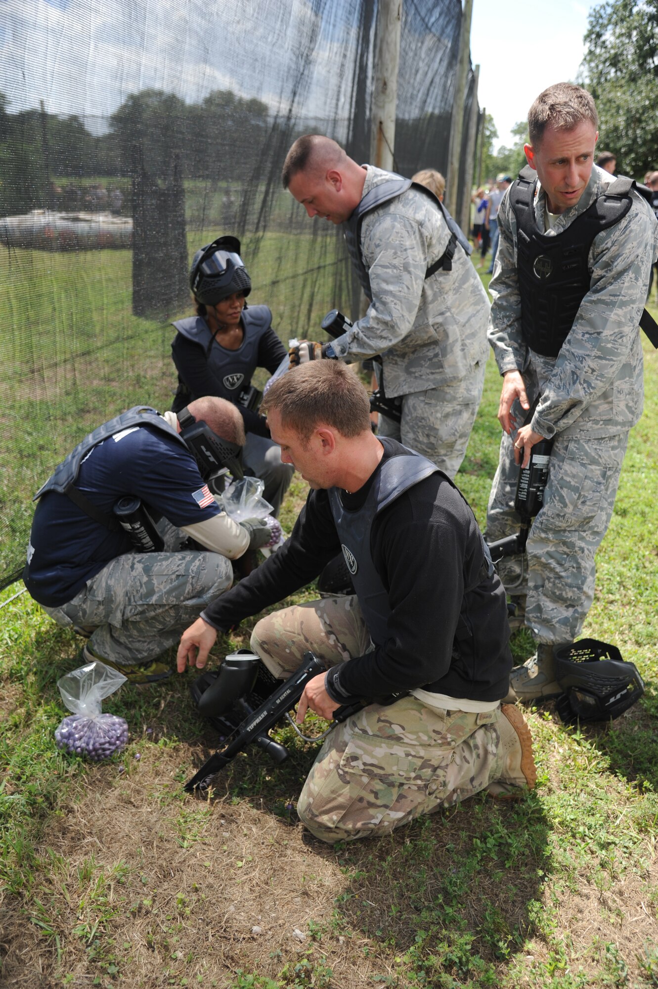 Members of the “Fab Five Commanders” team load their paintball guns with ammo during the Fisher House Fundraiser paintball tournament Sept. 12, 2014, at the paintball complex, Keesler Air Force Base, Miss.  The event also included food, games and a dunking booth.  (U.S. Air Force photo by Kemberly Groue)