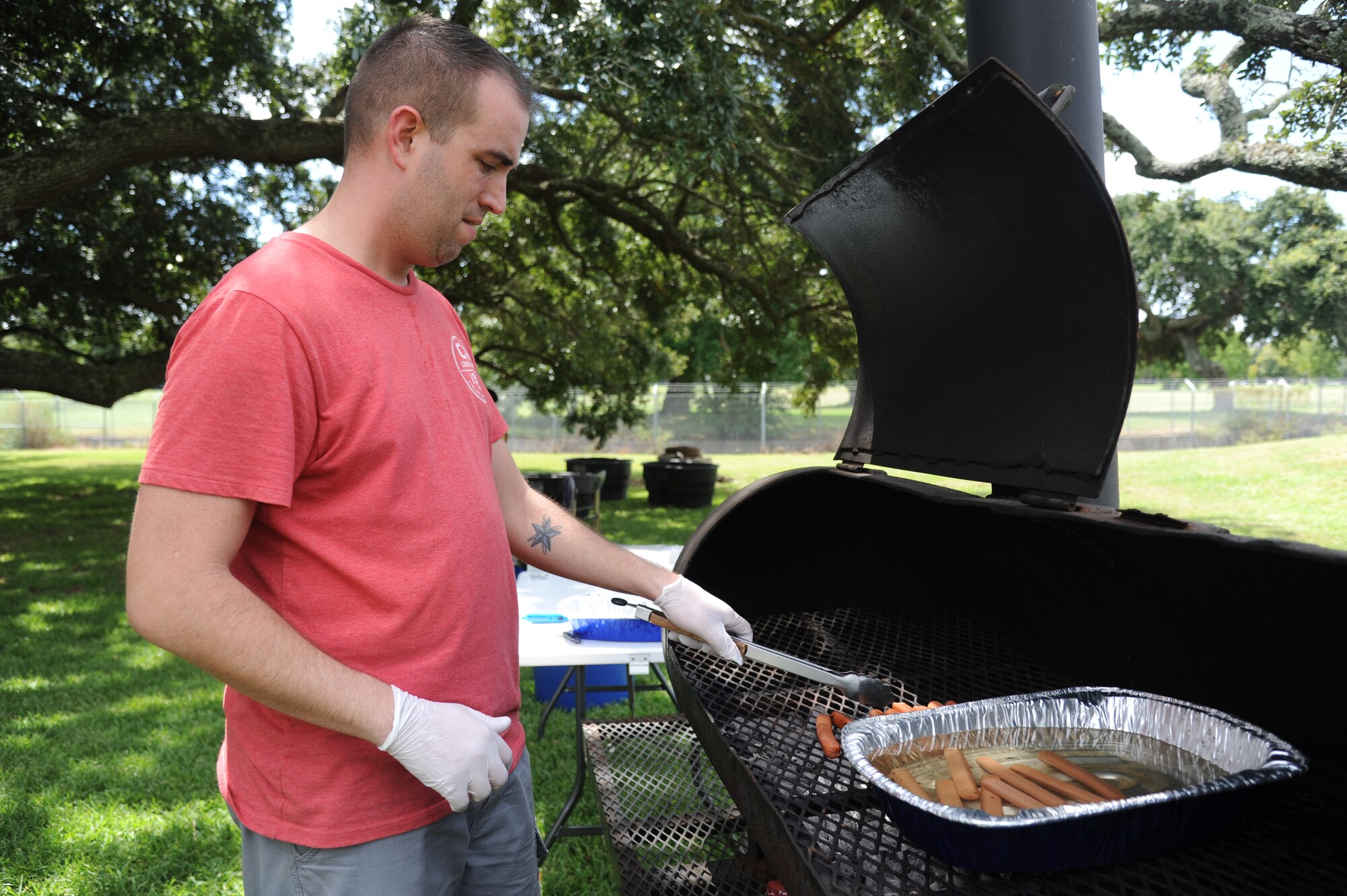 Tech. Sgt. Jeff Williams, 335th Training Squadron, grills hot dogs during the Fisher House Fundraiser paintball tournament Sept. 12, 2014, at the paintball complex, Keesler Air Force Base, Miss.  The event also included games and a dunking booth.  (U.S. Air Force photo by Kemberly Groue)
