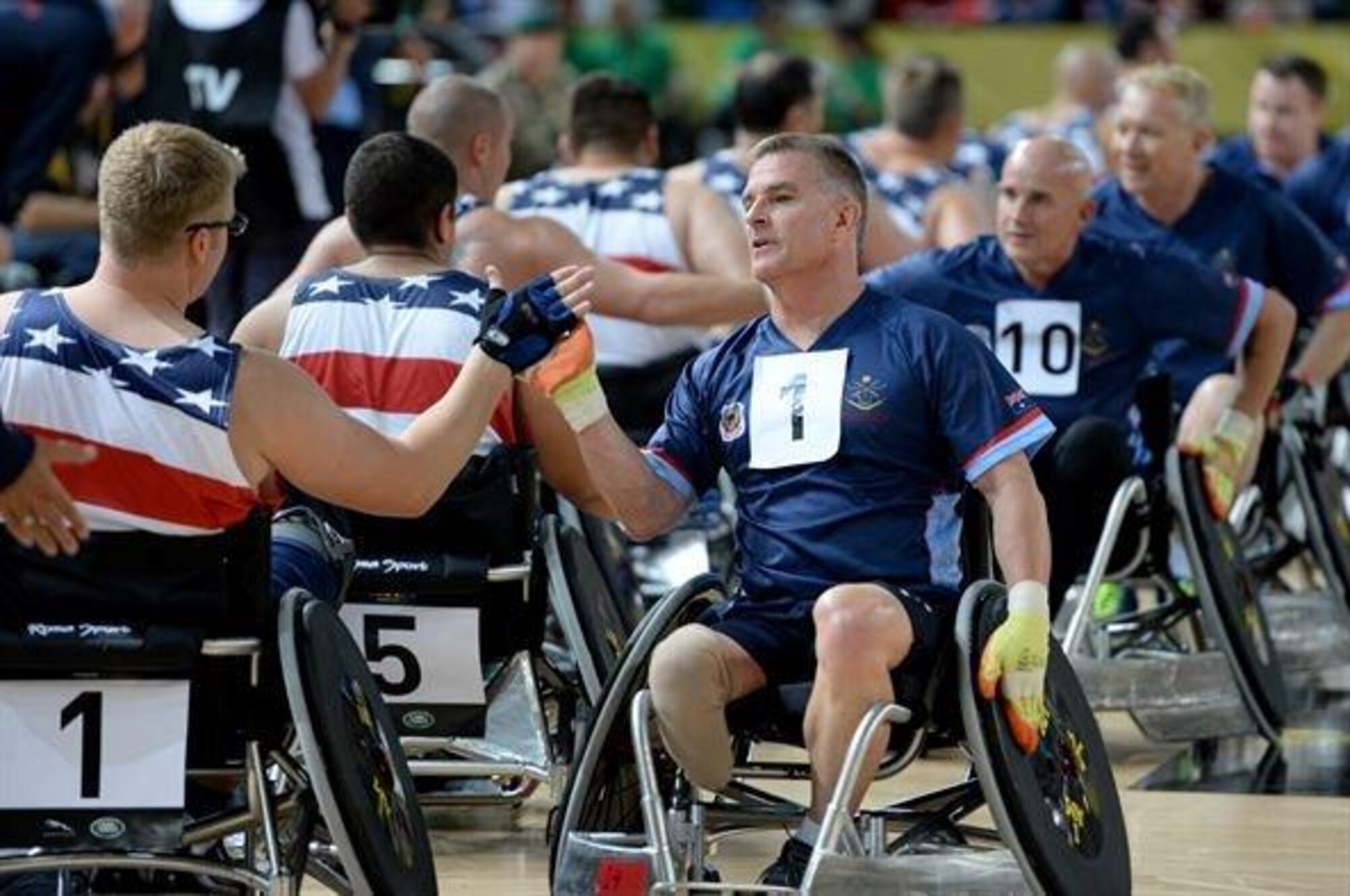 Members of the American and Australian wheelchair rugby teams congratulate each other after the U.S’s 14-4 victory over Australia Sept. 12, 2014, at the 2014 Invictus Games in London. Invictus Games is an international competition that brings together wounded, injured and ill service members in the spirit of friendly athletic competition. American Soldiers, Sailors, Airmen and Marines are representing the U.S. in the competition which is taking place Sept. 10-14. (U.S. Navy photo/Mass Communication Specialist 2nd Class Joshua D. Sheppard