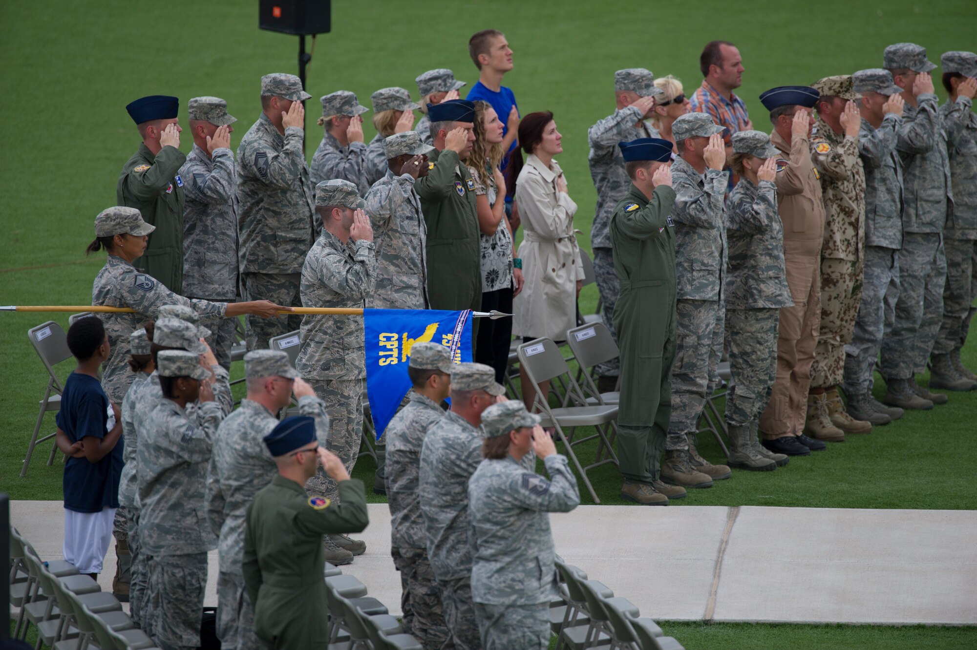 Members of Team Holloman render a salute as the American flag is lowered during the September 11th remembrance event at Holloman Air Force Base, N.M., Sept. 11. Team Holloman honored first responders and medical personnel that lost their lives during 9/11 by reciting prayers and creeds. Holloman AFB pays tribute to those fallen on September 11th annually with a ceremony at Heritage Park. (U.S. Air Force photo by Airman 1st Class Aaron Montoya / Released)