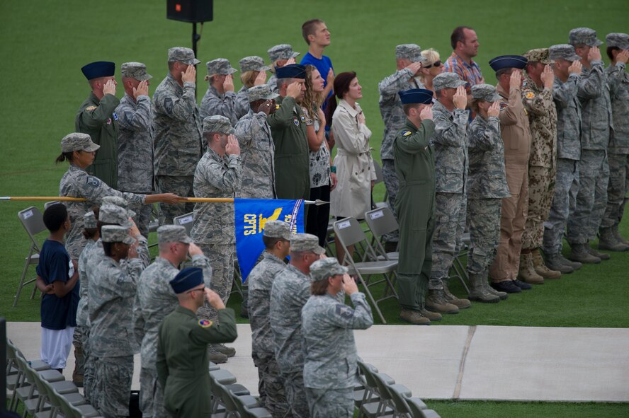 Members of Team Holloman render a salute as the American flag is lowered during the September 11th remembrance event at Holloman Air Force Base, N.M., Sept. 11. Team Holloman honored first responders and medical personnel that lost their lives during 9/11 by reciting prayers and creeds. Holloman AFB pays tribute to those fallen on September 11th annually with a ceremony at Heritage Park. (U.S. Air Force photo by Airman 1st Class Aaron Montoya / Released)