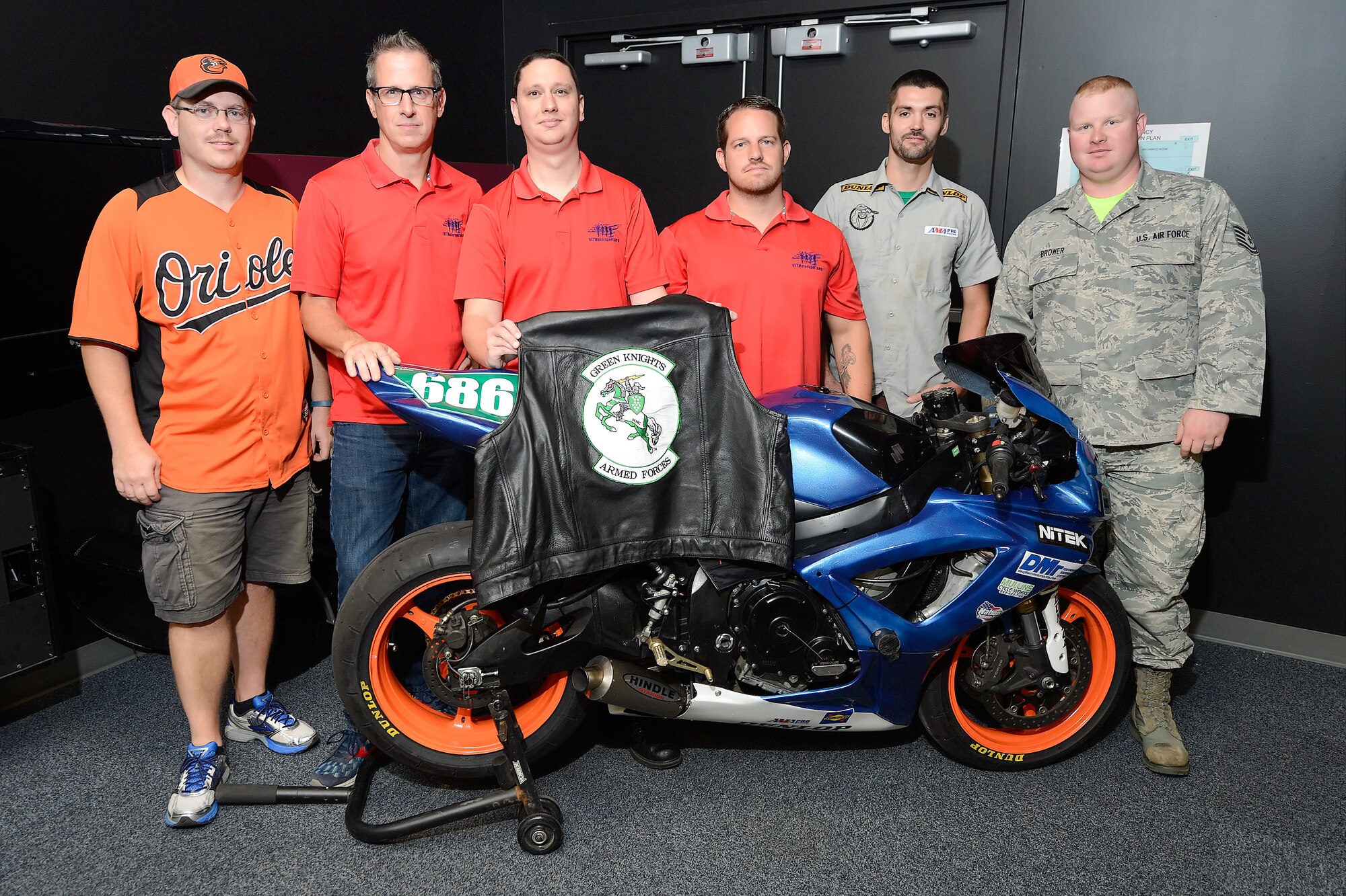 The Dover chapter of the Green Knights motorcycle club hosted VETMotorsports for a program overview discussion and are shown posing with a Suzuki GSXR 600 racing motorcycle and leather vest with the club's patch on Sept. 12, 2014, at Dover Air Force Base, Del. VETMotorsports embeds wounded warriors with motorsport racing teams across the country. From left to right are: Master Sgt. Nat Hudson, 166th Maintenance Operations Flight, Delaware Air National Guard, Peter Cline, Executive Director/Founder of VETMotorsports, David Fisher, U.S. Navy combat injured veteran, Yaunce Long, Marine Corps combat injured veteran, Brian Mullins, American Motorcycle Association Supersport racer and owner of Mullins Cycle Service and Tech. Sgt. Hank Brower, 436th Maintenance Group. (U.S. Air Force photo/Greg L. Davis)