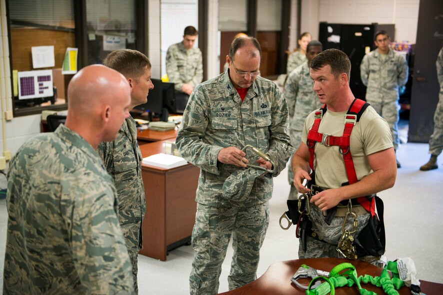 U.S. Air Force Staff Sgt. Gary Wilder, 23d Operations Support Squadron NCO in charge of airfield systems, details proper usage of a tower climbing harness to group and squadron commanders Sept. 12, 2014, at Moody Air Force Base, Ga. The air traffic control and landing systems flight, previously attached to the 23d Communications Squadron, has been realigned to the 23d OSS to support the 23d Fighter Group. (U.S. Air Force photo by Airman 1st Class Ryan Callaghan/Released)