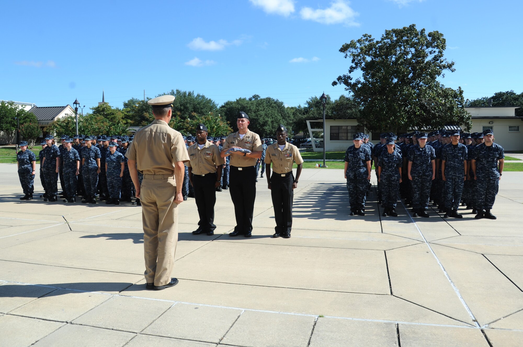 Members of the Center for Naval Aviation Technical Training Unit Keesler stand at attention as they follow proper procedure for retiring a worn U.S. Flag, during a remembrance ceremony Sept. 11, 2014, Keesler Air Force Base, Miss.  The ceremony also honored those who lost their lives during the 9/11 attacks. (U.S. Air Force photo by Kemberly Groue)