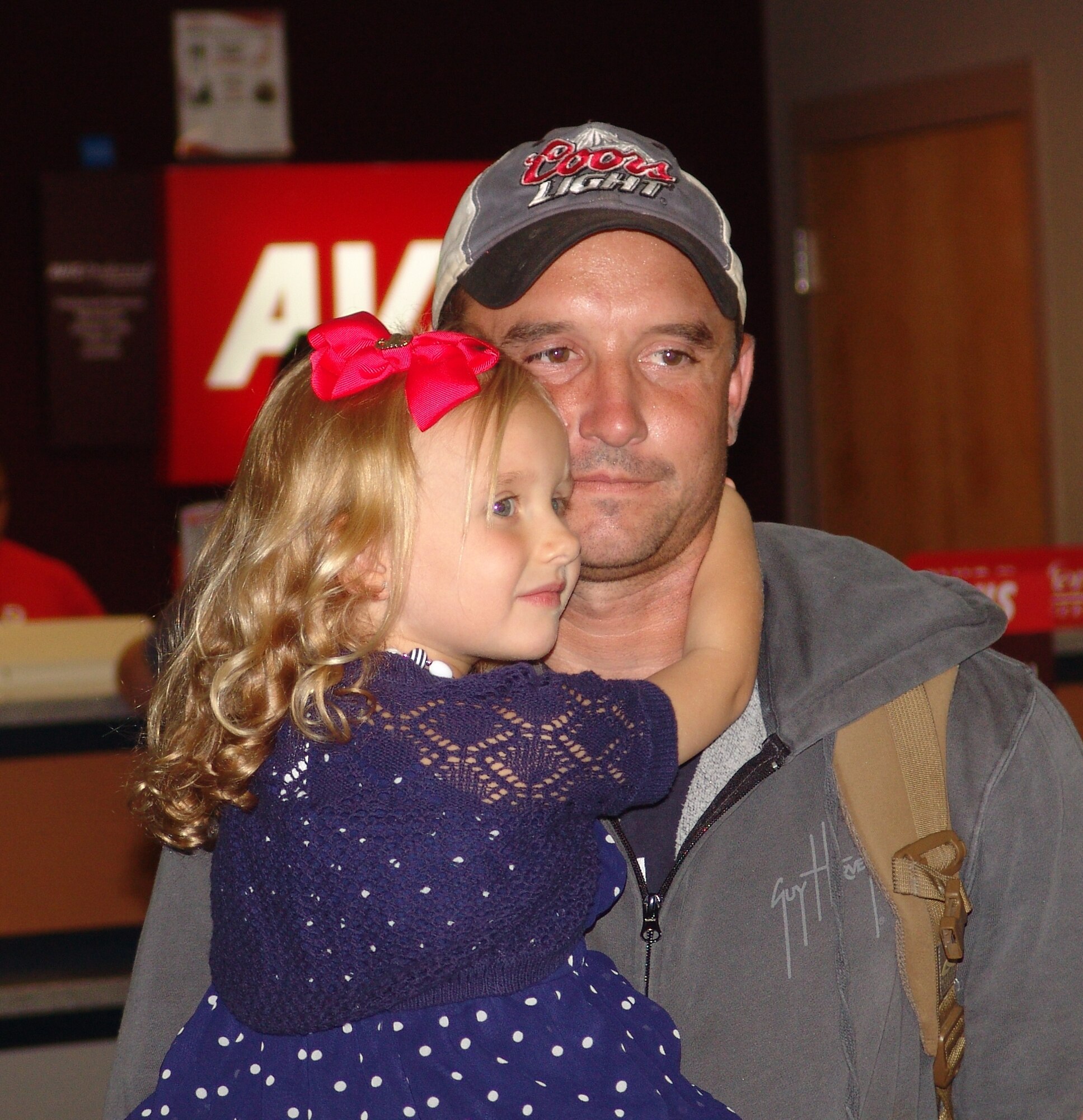 Senior Airman Joshua Frehner's daughter, Devyn, welcomes him home from deployment Sept. 14. Frehner and fellow teammates Tech Sgt. Joseph Burke and Staff Sgt. Michael Edwards were the last explosive ordnance disposal team to support combat commanders in Afghanistan. (USAF photo/Lois Walsh) 

