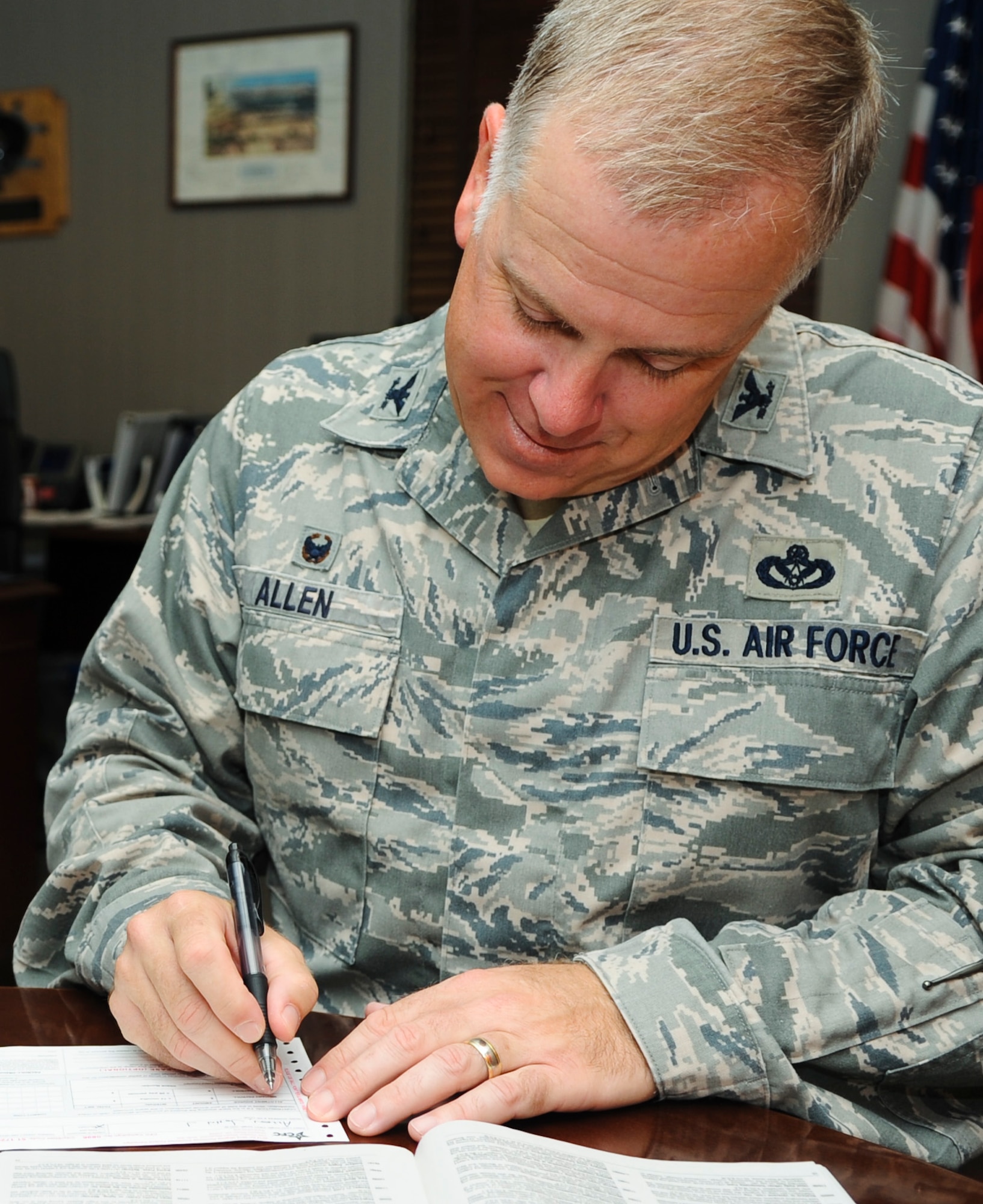U.S. Air Force Col. John J. Allen Jr., 633rd Air Base Wing commander, complete a Combined Federal Campaign donation form at Langley Air Force Base, Va., Sept. 15, 2014. The 2014 Joint Base Langley-Eustis CFC started Sept. 15 and ends Oct. 31, and the goal is $158,664. (U.S. Air Force photo by Senior Airman Austin Harvill/Released)