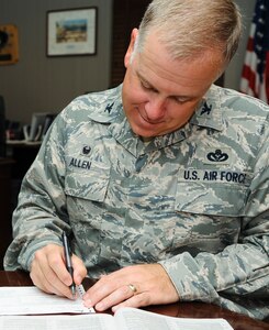 U.S. Air Force Col. John J. Allen Jr., 633rd Air Base Wing commander, complete a Combined Federal Campaign donation form at Langley Air Force Base, Va., Sept. 15, 2014. The 2014 Joint Base Langley-Eustis CFC started Sept. 15 and ends Oct. 31, and the goal is $158,664. (U.S. Air Force photo by Senior Airman Austin Harvill/Released)