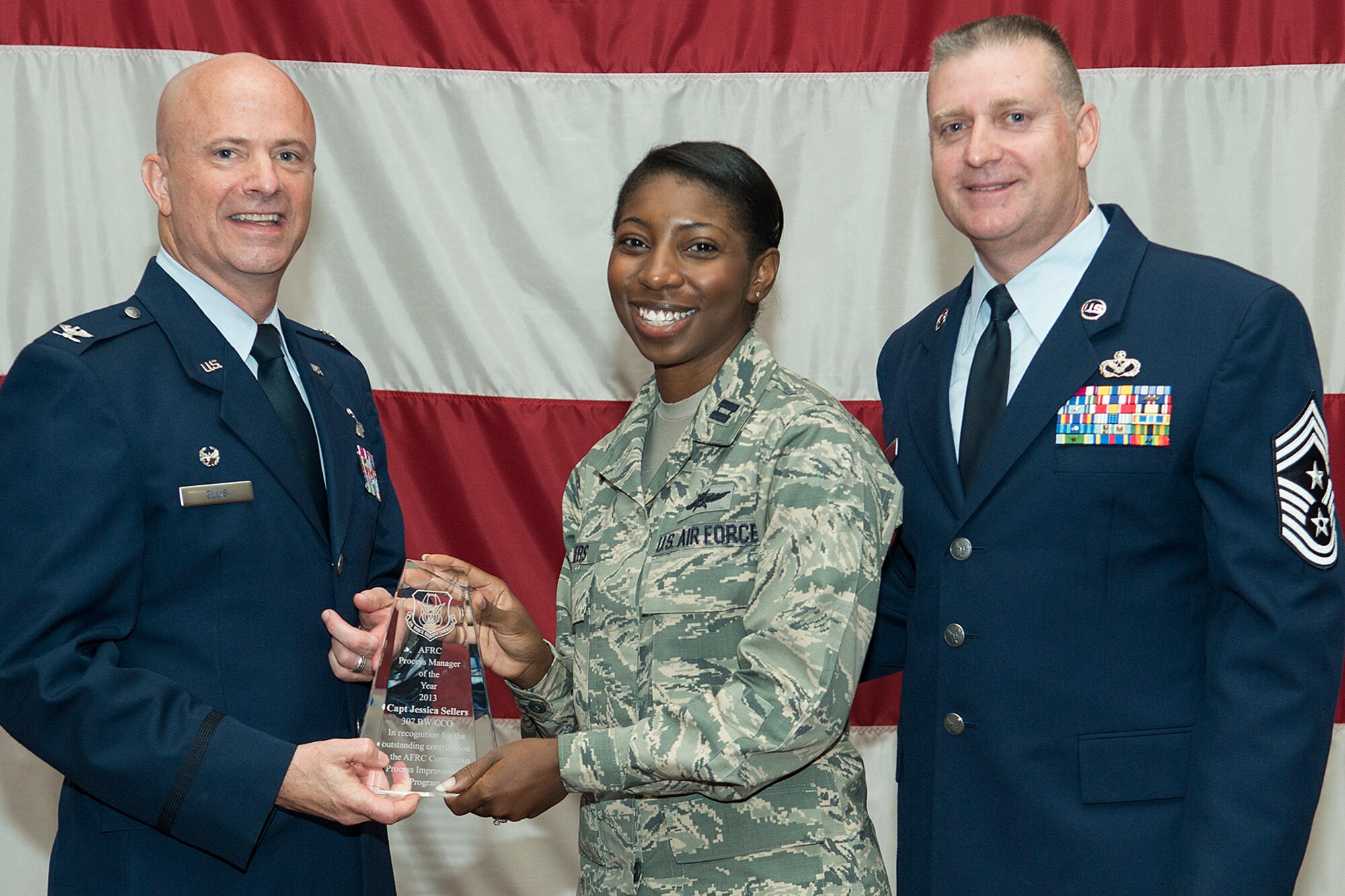 U.S. Air Force Capt. Jessica Sellers receives an award during a 307th Bomb Wing Commander's Call, Sept. 7, 2014, Barksdale Air Force Base, La. Sellers was selected as the Air Force Reserve Command's Process Manager of the Year for 2013. (U.S. Air Force photo by Master Sgt. Greg Steele/Released)