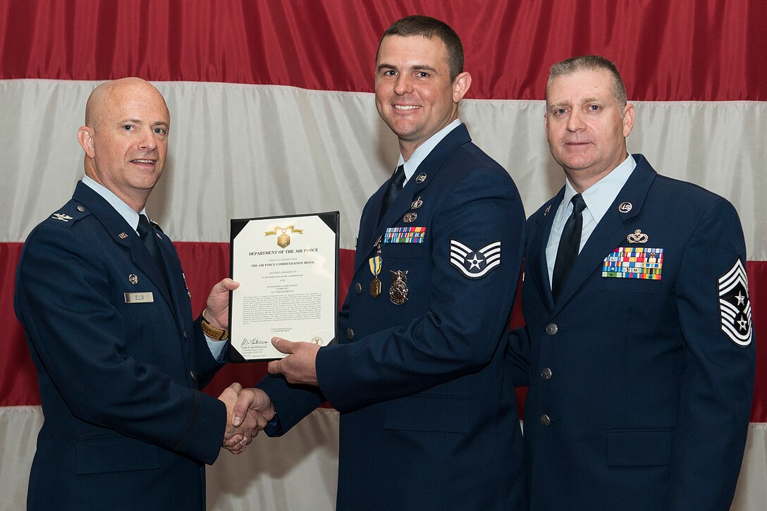 U.S. Air Force Staff Sgt. Jacob Hempstead is awarded the Air Force Commendation Medal during a 307th Bomb Wing Commander's Call, Sept. 7, 2014, Barksdale Air Force Base, La. Hempstead distinguished himself by outstanding achievement in helping save the life of a fellow Airman in physical distress during a flight to a deployed location. (U.S. Air Force photo by Master Sgt. Greg Steele/Released)