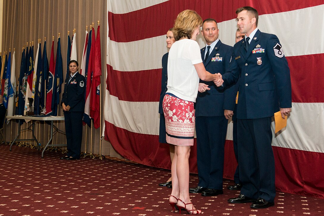 Kara Lowrie, representing Acadiana Mortgage, presents U.S. Air Force Master Sgt. Jonathan Rapelje with a gift certificate in recognition of being selected the Senior Noncommissioned Officer of the Quarter, Sept. 7, 2014, Barksdale Air Force Base, La. Also receiving gift certificates is Airman of the Quarter winner Senior Airman Jacquelyn Espinoza and Noncommissioned Officer of the Quarter Tech. Sgt. Mark Chumley. (U.S. Air Force photo by Master Sgt. Greg Steele/Released)