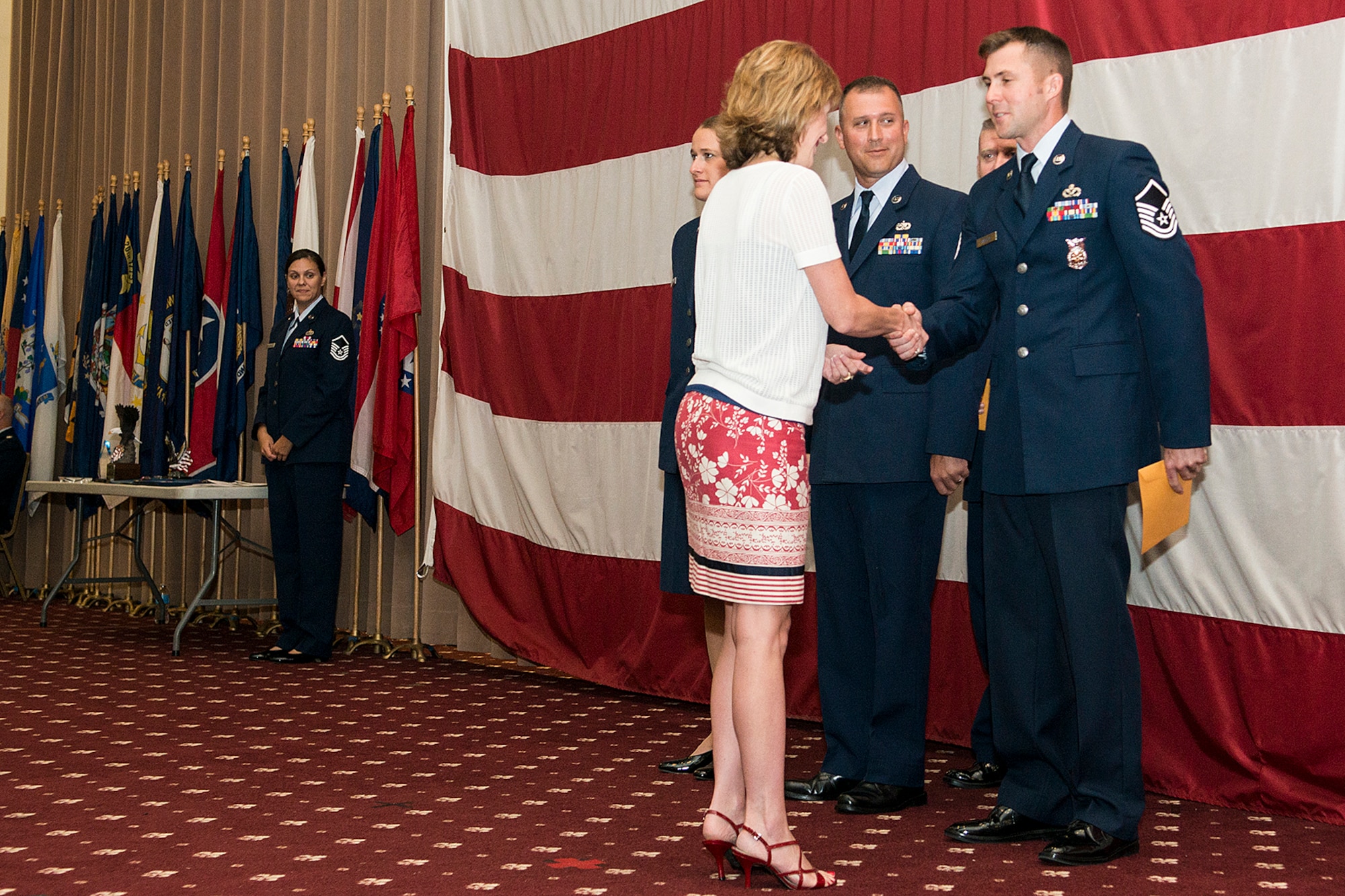 Kara Lowrie, representing Acadiana Mortgage, presents U.S. Air Force Master Sgt. Jonathan Rapelje with a gift certificate in recognition of being selected the Senior Noncommissioned Officer of the Quarter, Sept. 7, 2014, Barksdale Air Force Base, La. Also receiving gift certificates is Airman of the Quarter winner Senior Airman Jacquelyn Espinoza and Noncommissioned Officer of the Quarter Tech. Sgt. Mark Chumley. (U.S. Air Force photo by Master Sgt. Greg Steele/Released)