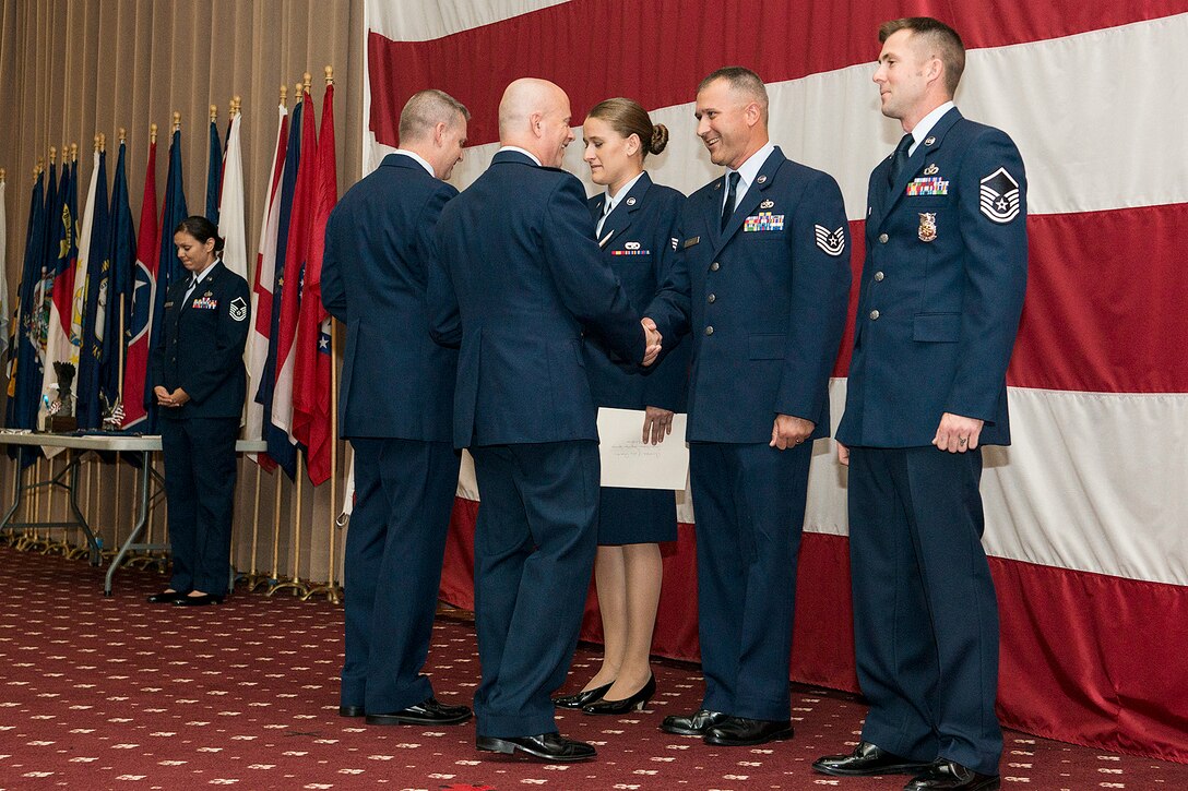 U.S. Air Force Col. Jonathan Ellis, 307th Bomb Wing commander, congratulates Tech. Sgt. Mark Chumley for being selected as the Noncommissioned Officer of the Quarter, Sept. 7, 2014, Barksdale Air Force Base, La. Chumley is assigned to the 307th RED HORSE, and also receiving congratulations is Airman of the Quarter winner Senior Airman Jacquelyn Espinoza, 307th RED HORSE, and Senior Noncommissioned Officer of the Quarter winner Master Sgt. Jonathan Rapelje, 307th Civil Engineer Squadron. (U.S. Air Force photo by Master Sgt. Greg Steele/Released)