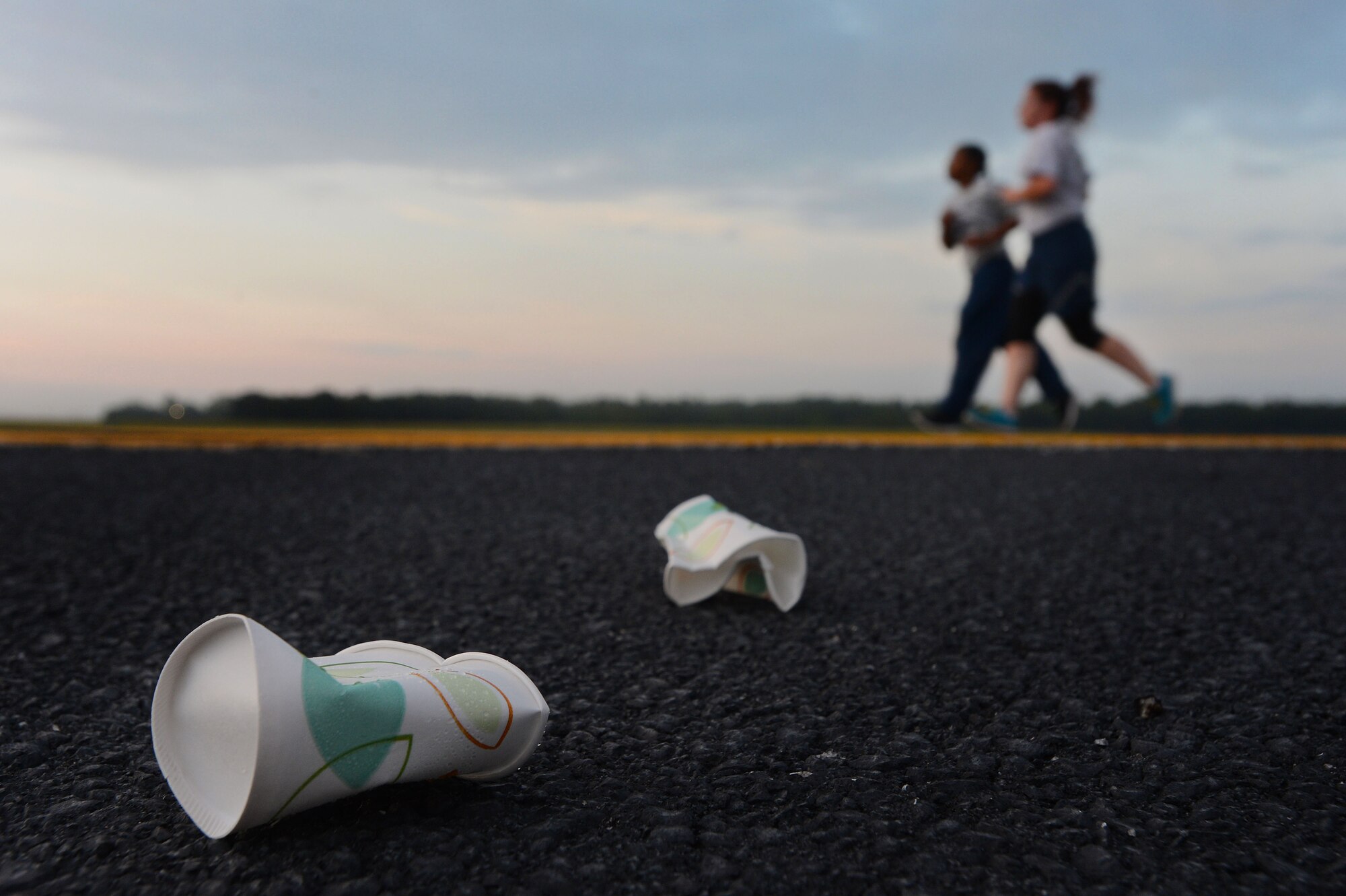 Crushed paper cups lay on the flightline during a 5k run at Shaw Air Force Base, S.C., Sept. 11, 2014. Two water stands were set up for Team Shaw members to hydrate during the 9/11 memorial run. (U.S. Air Force photo by Airman 1st Class Jensen Stidham/Released) 