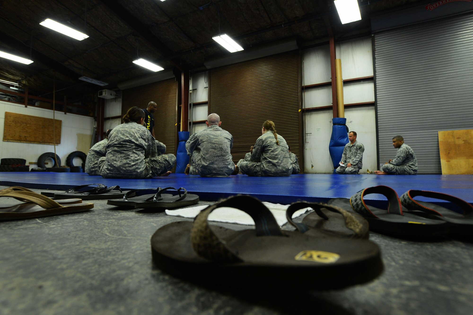 Members of Team Shaw watch demonstrations from an instructor during a Modern Army Combative Program course at Shaw Air Force Base, S.C., Sept. 9, 2014. Students are required to not wear shoes while on the mat so that the mat does not get torn up. (U.S. Air Force photo by Airman 1st Class Jensen Stidham/Released)